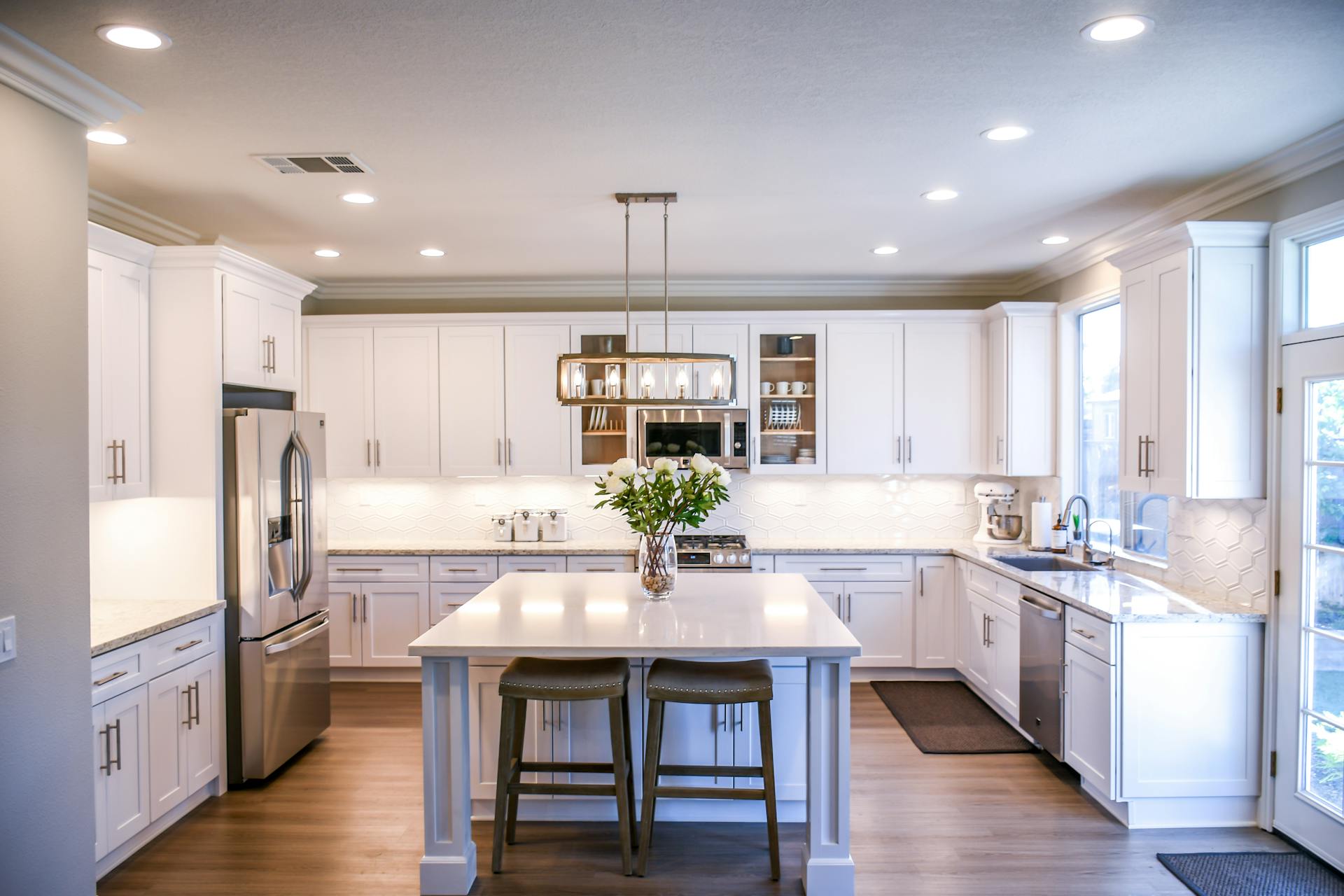 White kitchen with island and wood floors in a residential house